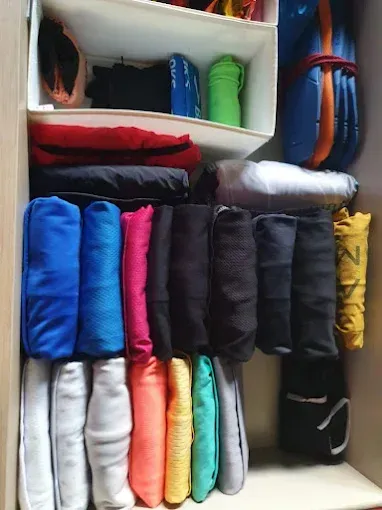 Cajón organizado con ropa colorida doblada, incluyendo camisas, pantalones y calcetines.