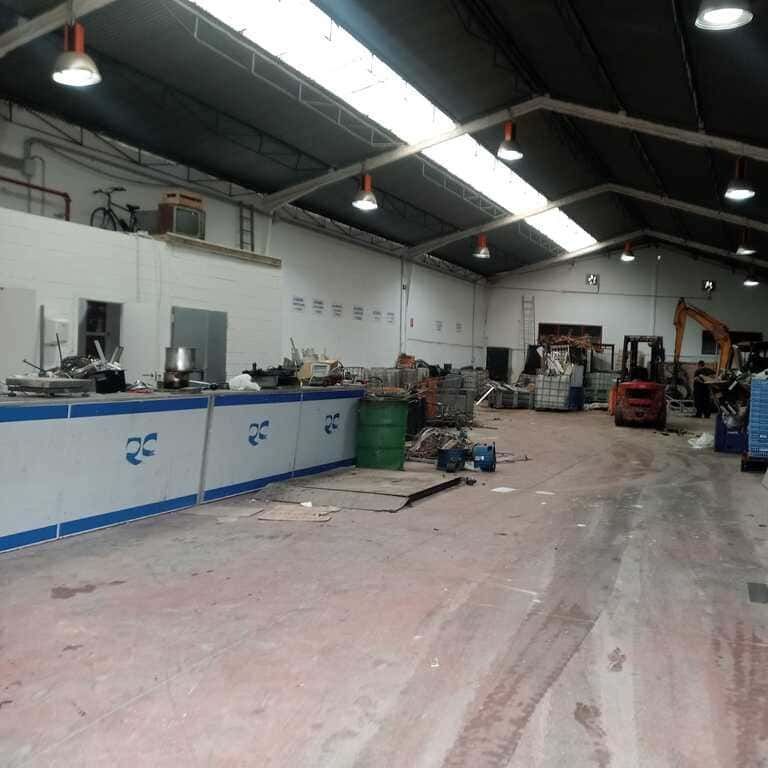Un gran almacén con una carretilla elevadora en el medio.