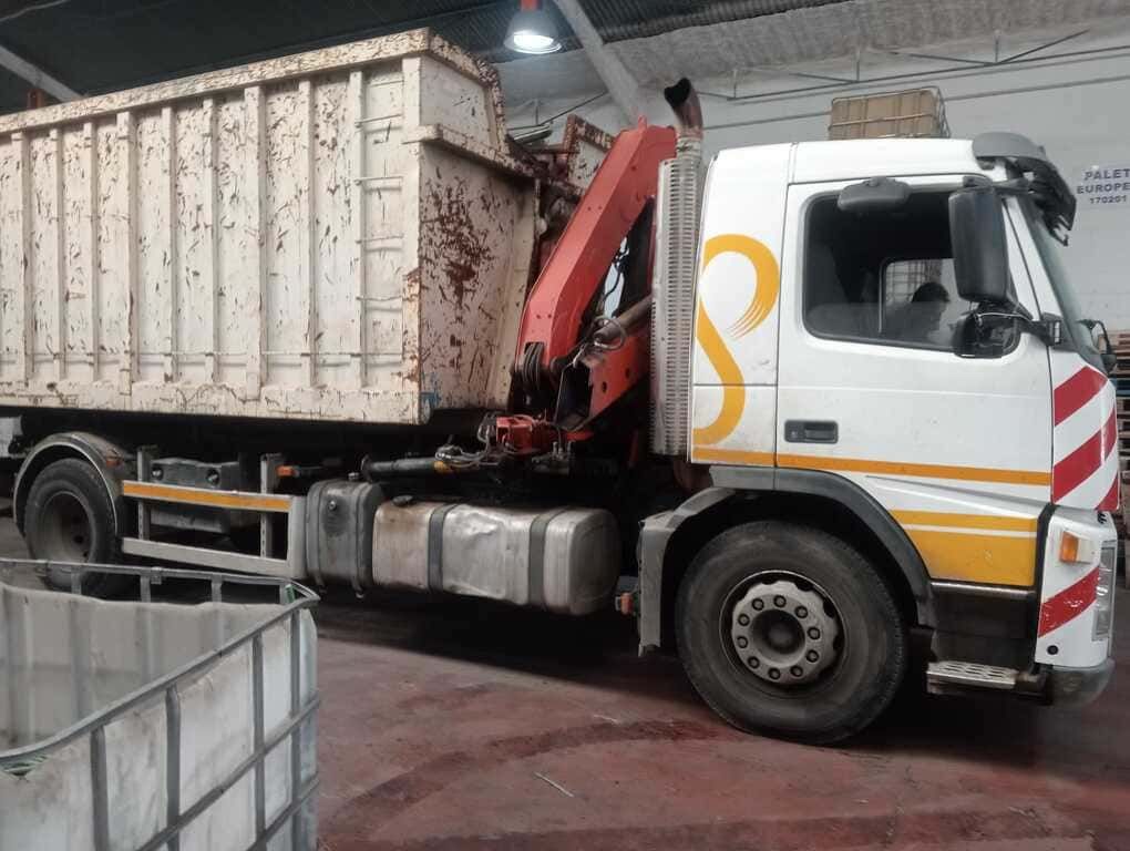 Un camión blanco con la letra s en el costado.
