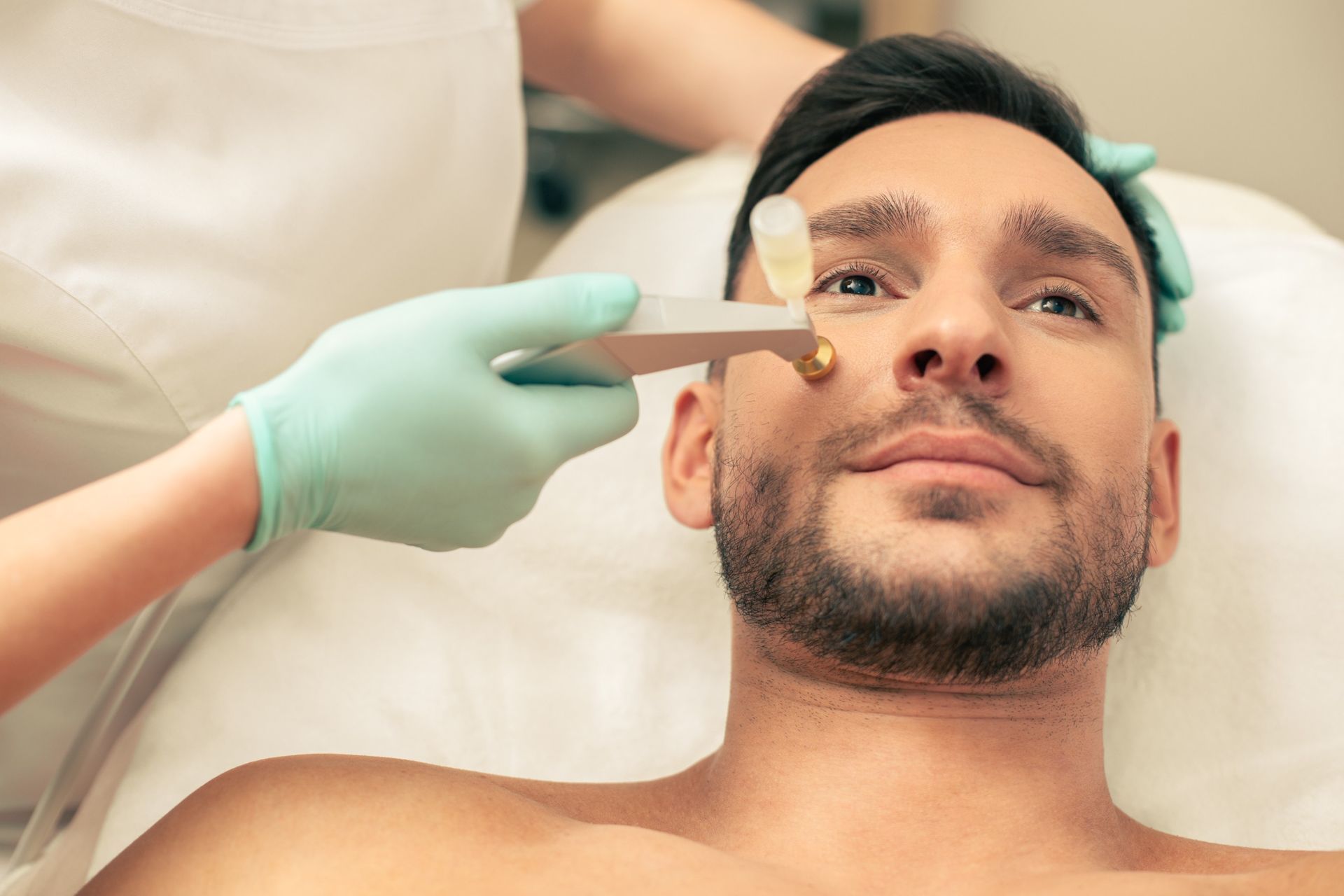 Un hombre está recibiendo un tratamiento facial en un salón de belleza.