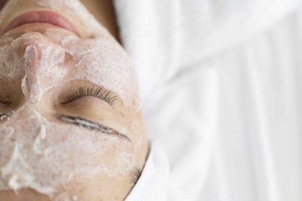 Una mujer está acostada en una cama con una máscara de espuma en la cara.