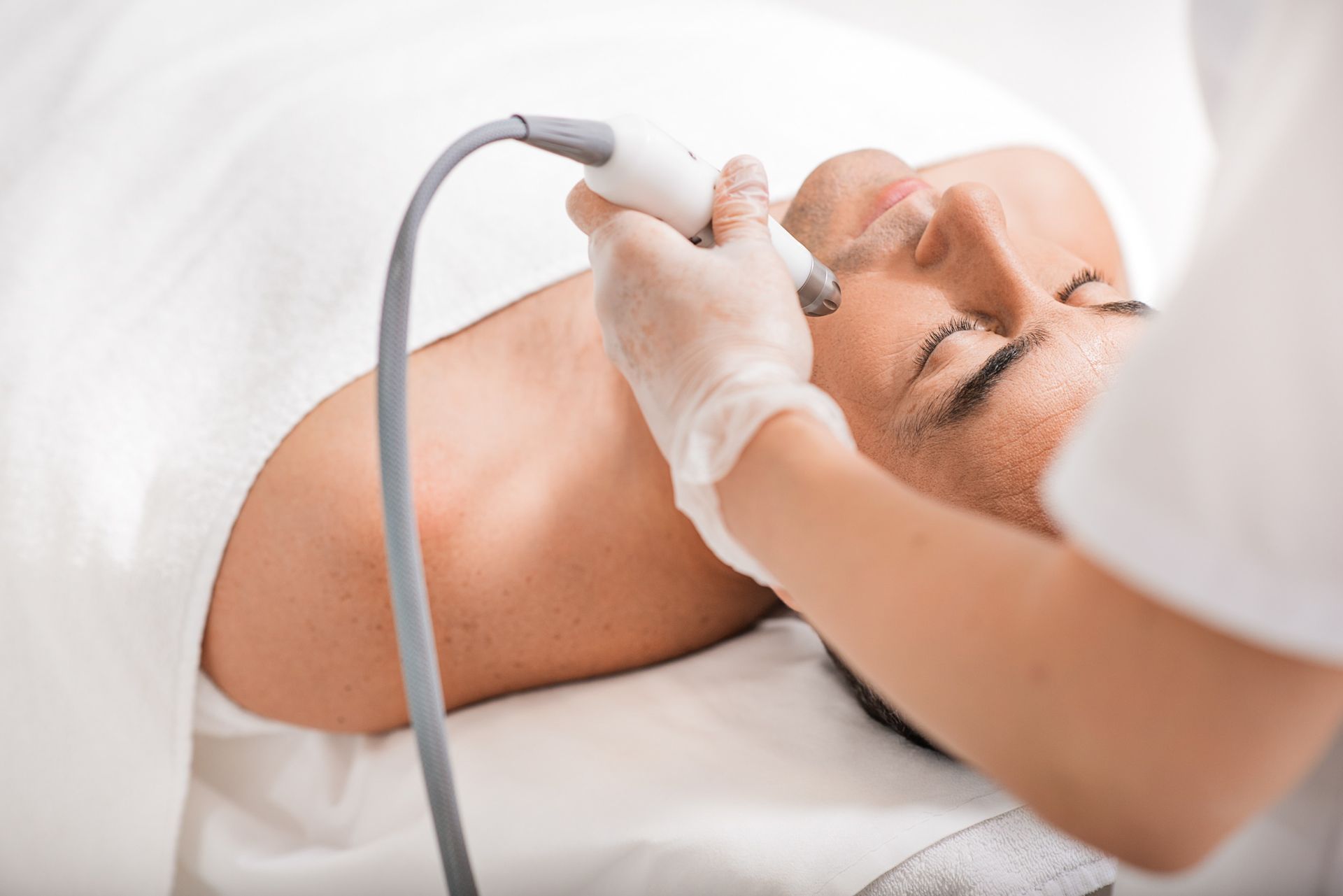 Un hombre está recibiendo un tratamiento facial en un salón de belleza.