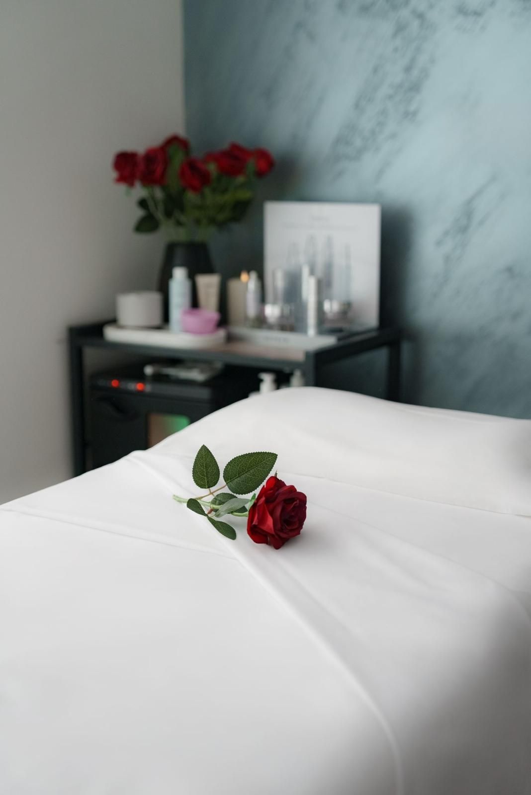 Una rosa roja está en una mesa de masajes en un spa.
