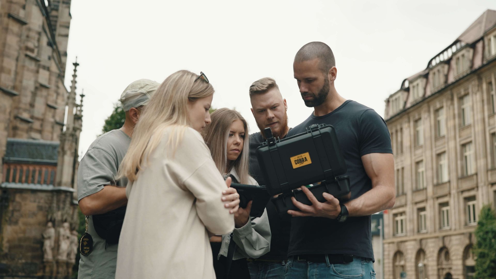 Eine Gruppe Leute steht um einen Mann herum, der einen Laptop hält.