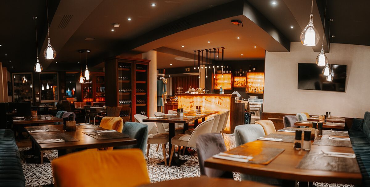 Ein Restaurant mit Tischen und Stühlen und einem Fernseher an der Wand.