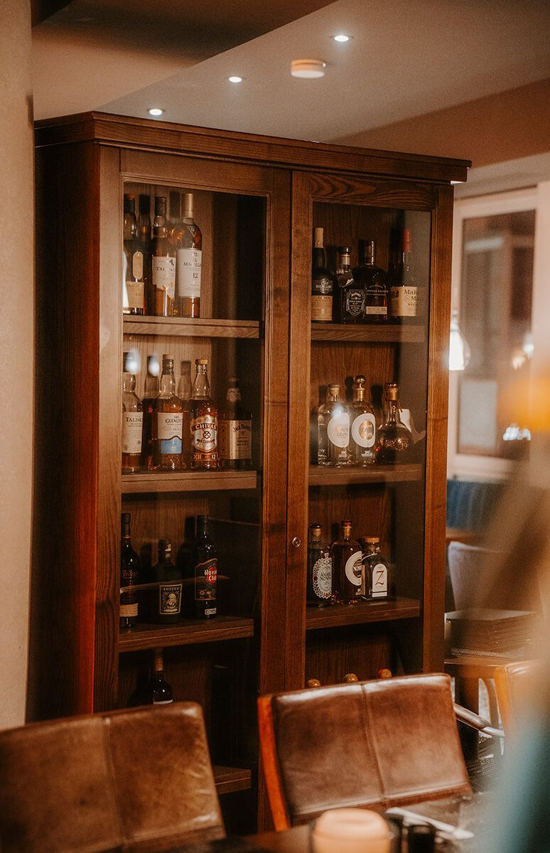 Ein Holzschrank voller Alkoholflaschen in einem Esszimmer.