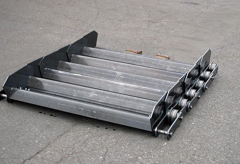 Auf dem Boden liegt ein Förderband aus Metall.