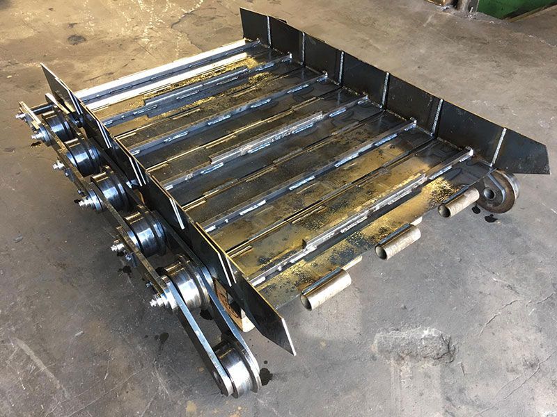 Auf einem Betonboden steht ein Förderband aus Metall.