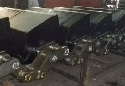 Eine Reihe von Metallteilen liegt auf einem Holztisch.