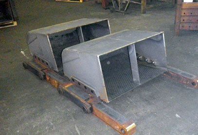 Auf einem Holztisch stehen zwei Metallboxen.