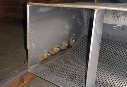 Auf einem Tisch liegt ein Stück Metall mit Löchern.