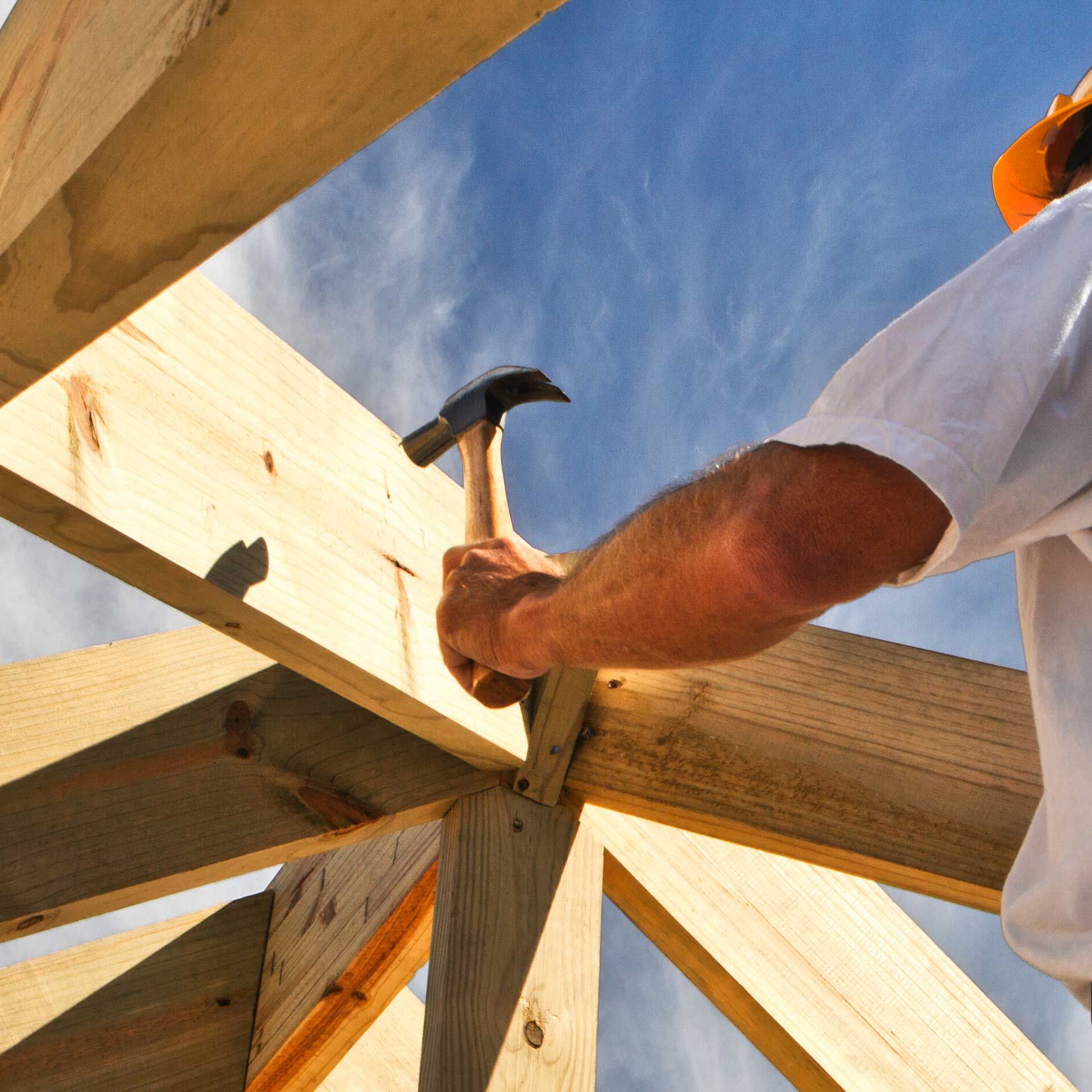 Un charpentier utilisant un marteau sur une charpente en bois