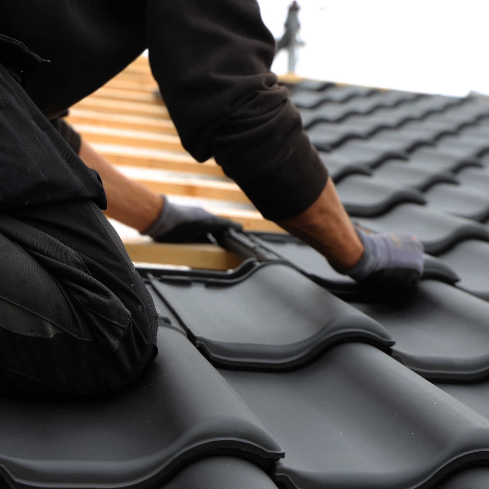 Les mains d'un artisan posant des tuiles