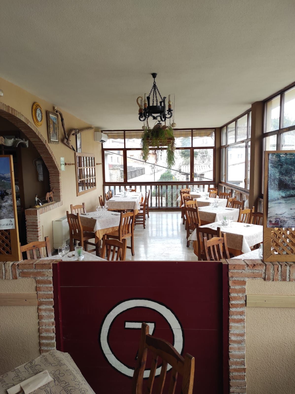 Un restaurante con mesas y sillas y un cartel que dice 7