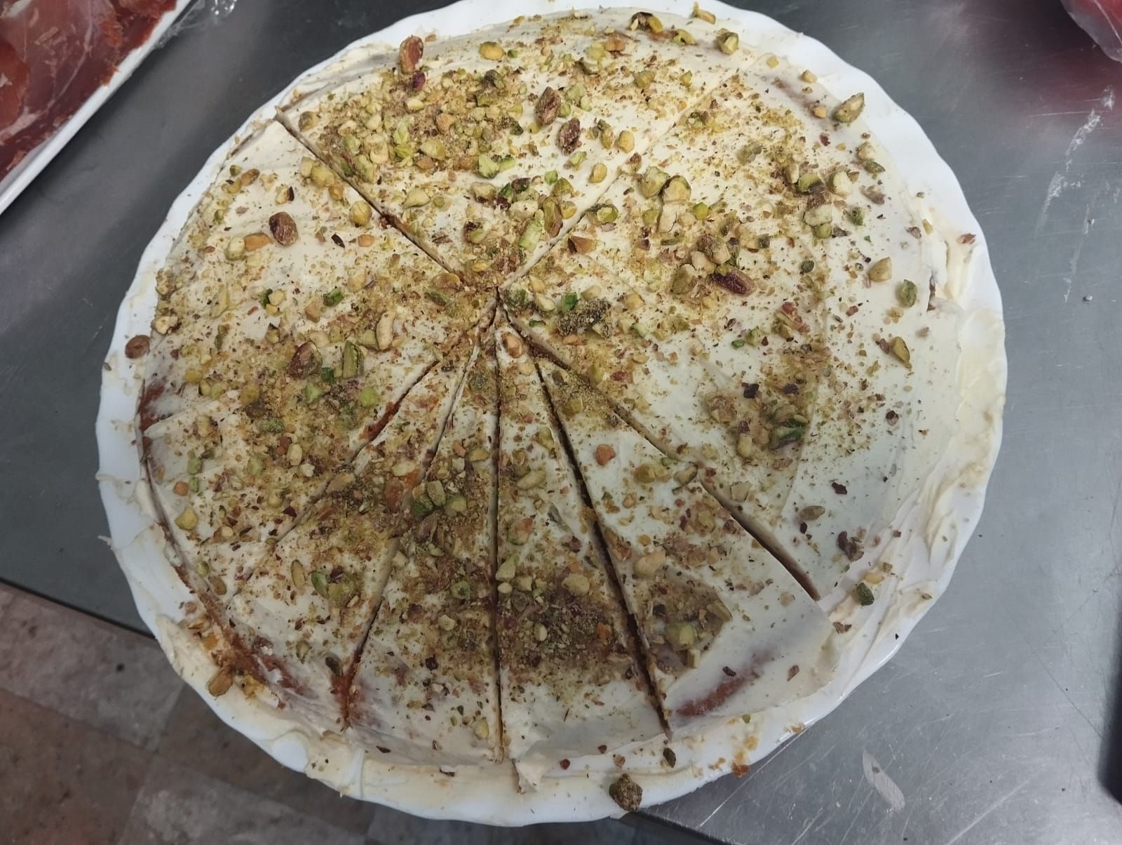 Una pizza con nueces encima está sobre una mesa.