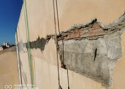 Un primer plano de una pared de ladrillos con un agujero en ella.