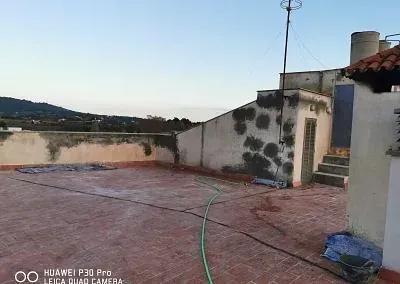 Un tejado con una manguera y una chimenea encima.