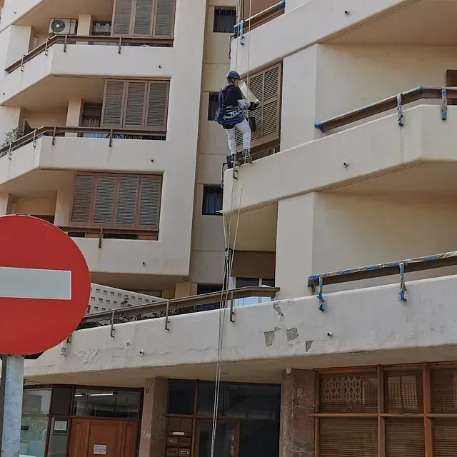 Un hombre está subiendo a un edificio junto a una señal de prohibido el paso.
