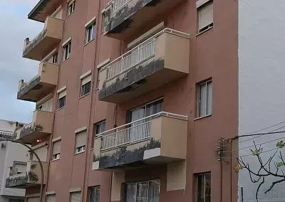 Un gran edificio de apartamentos con muchos balcones y ventanas.