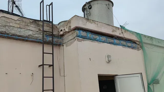 Una escalera está fijada al costado de un edificio.