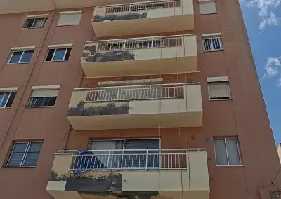 Un gran edificio de apartamentos con muchos balcones y ventanas.