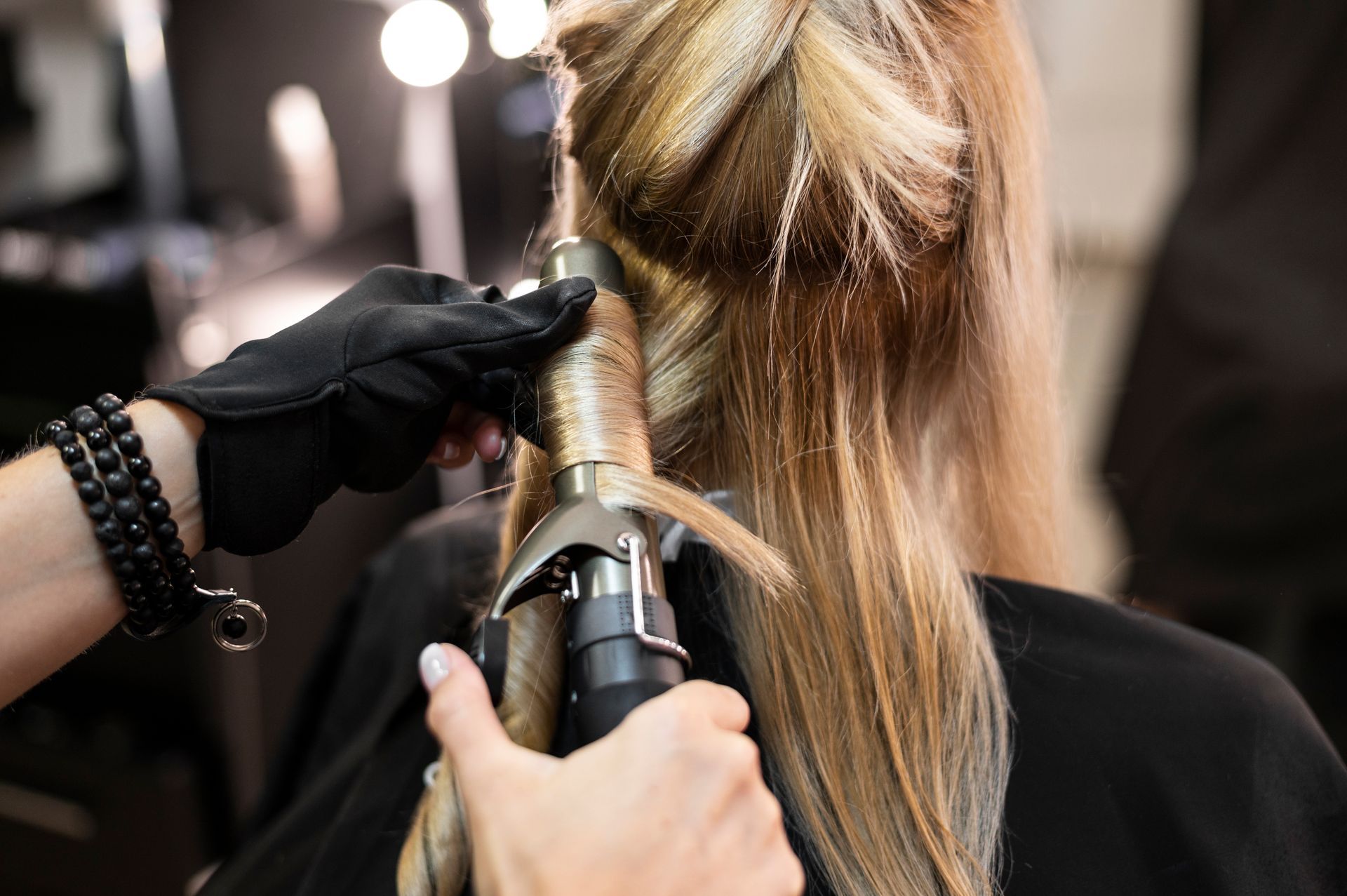 Mujer haciendose rulos en el pelo en un salón