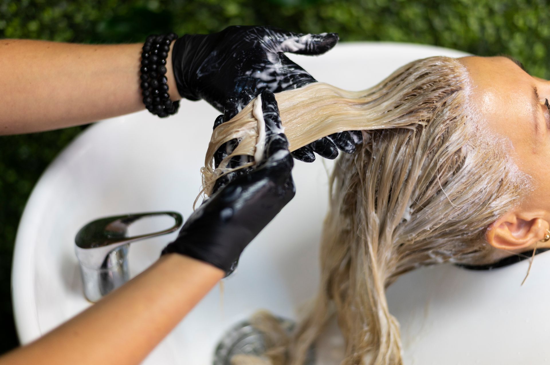 Mujer lavando pelo en un salón de belleza