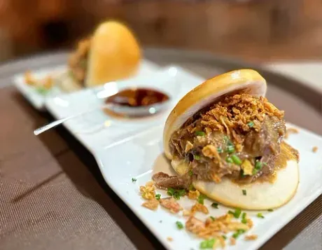Un primer plano de un sándwich en un plato sobre una mesa.