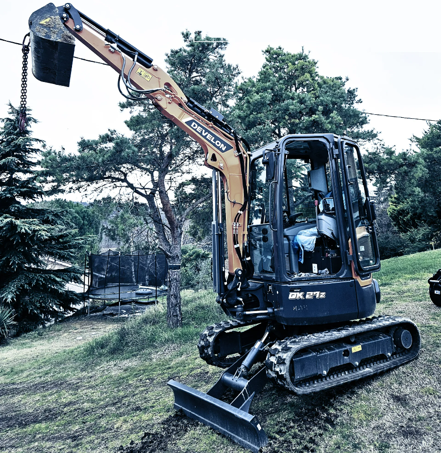 Camion sur la route qui porte une mini-pelle