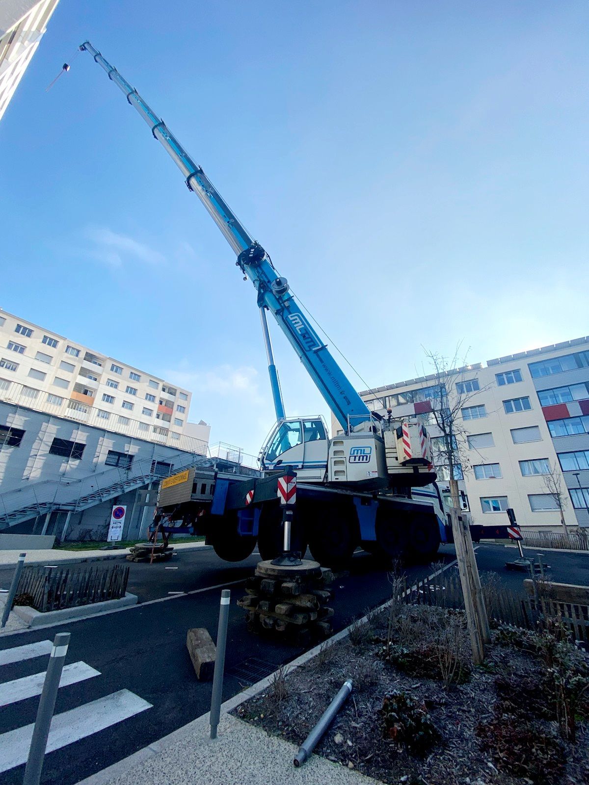 Grue mobile fixée et déployée devant un ciel bleu