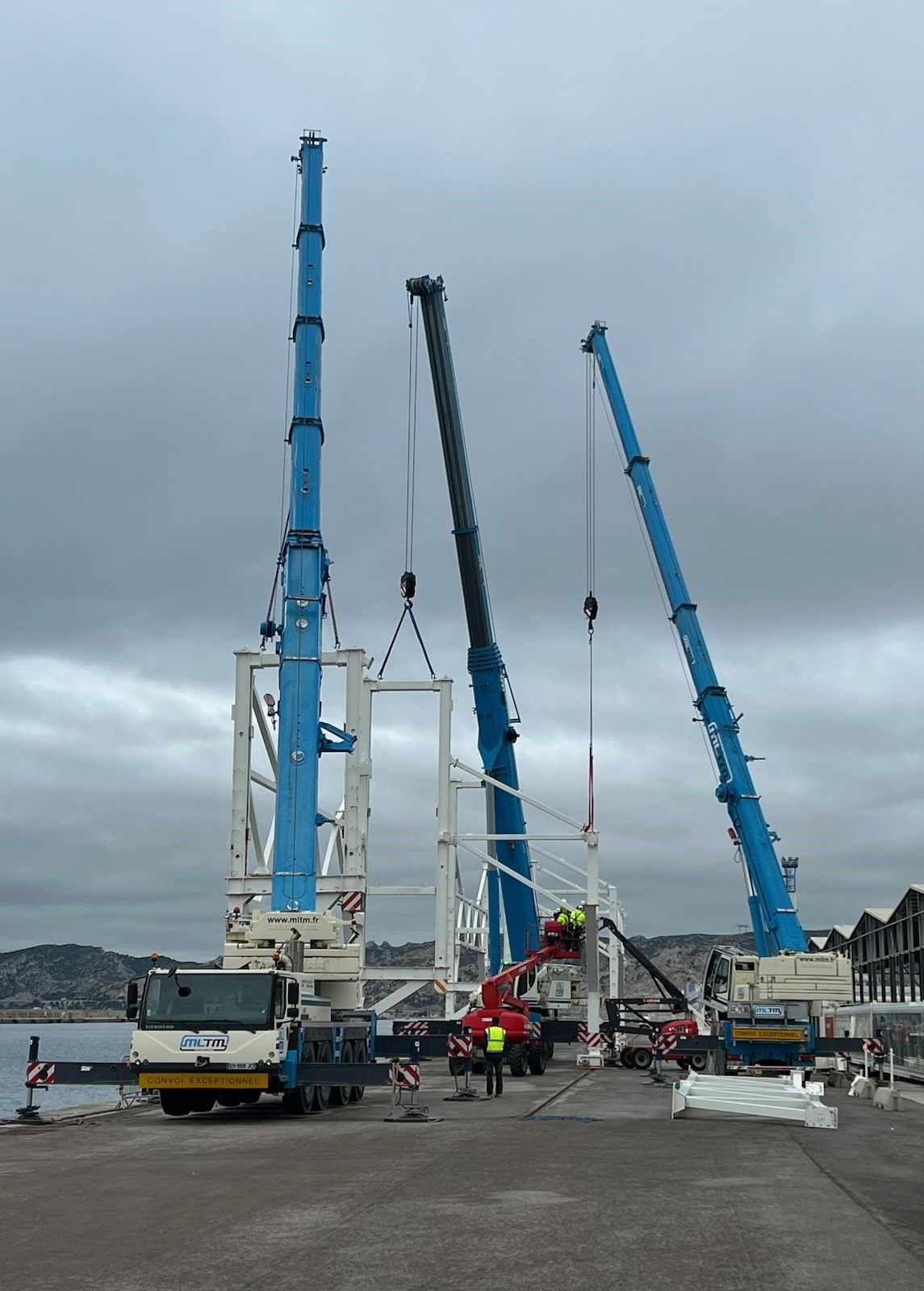 Trois bras de grues déployés 
