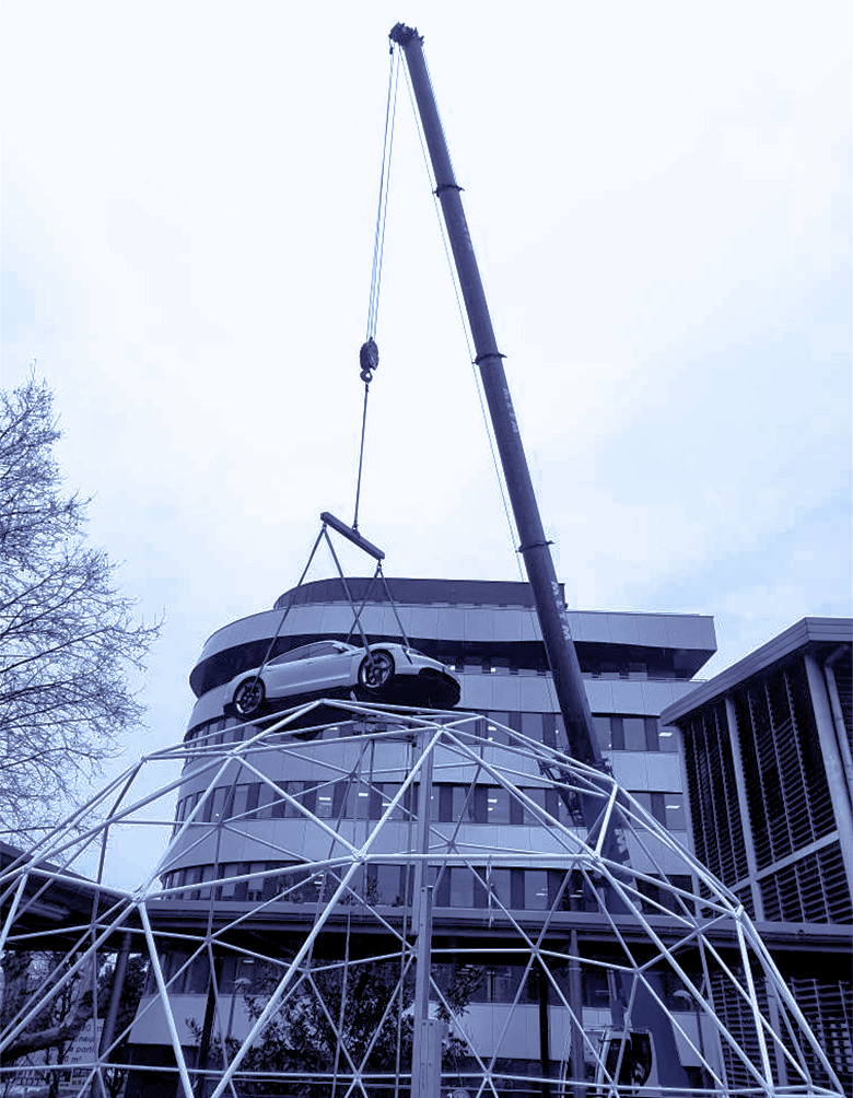 Une voiture suspendue par la grue d'un engin