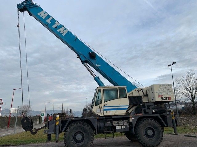 Camion avec de grandes roues et une grue bleue