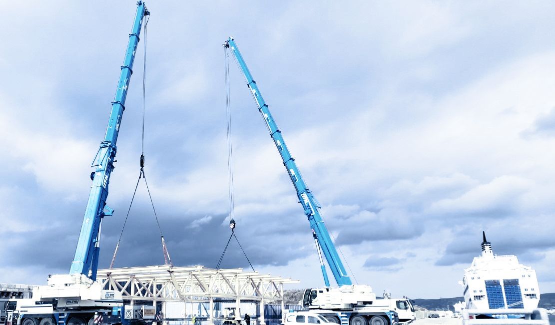 Camion grue qui soulève un container