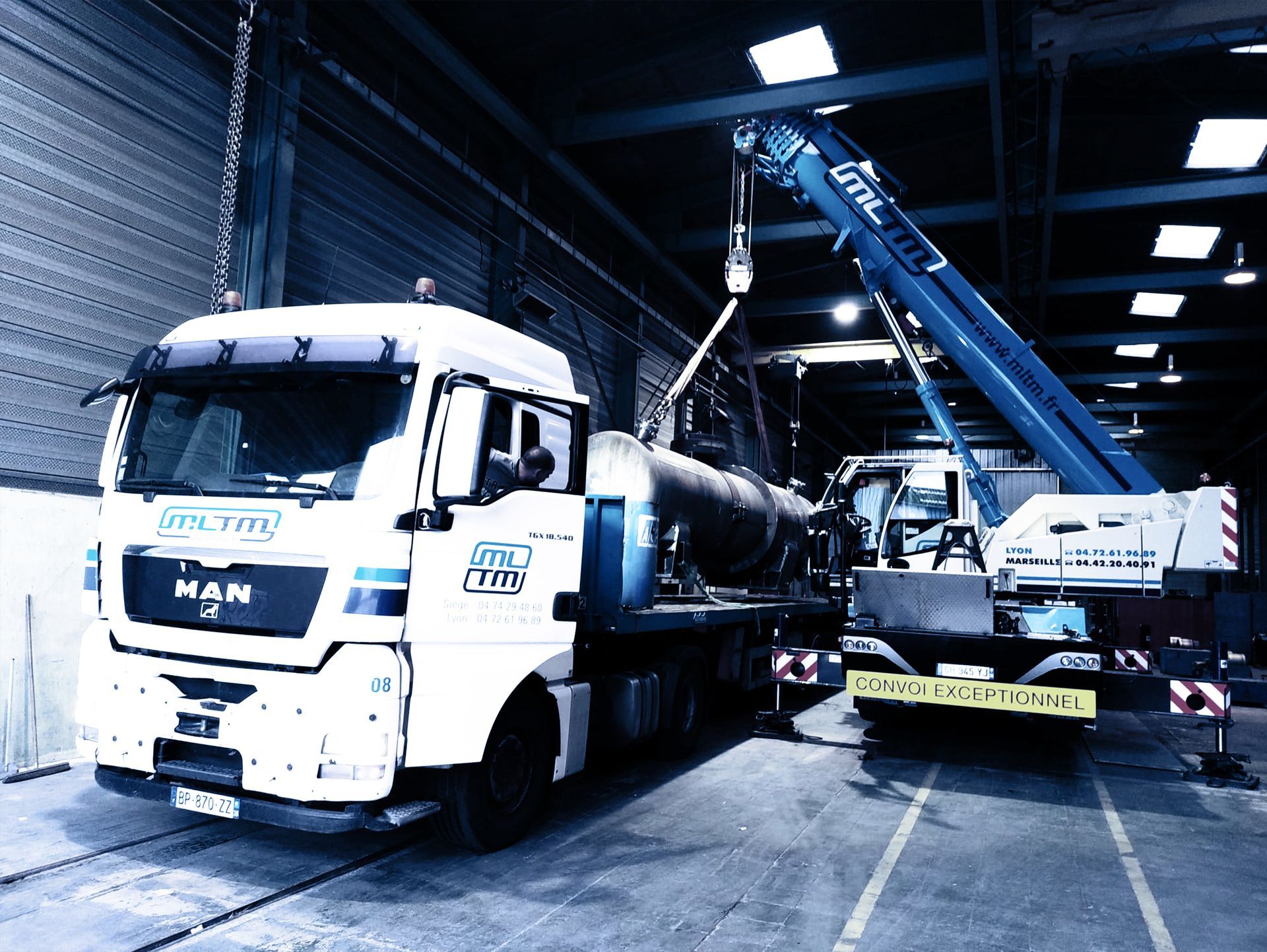 Un camion de transport et son bras soulevant un objet volumineux