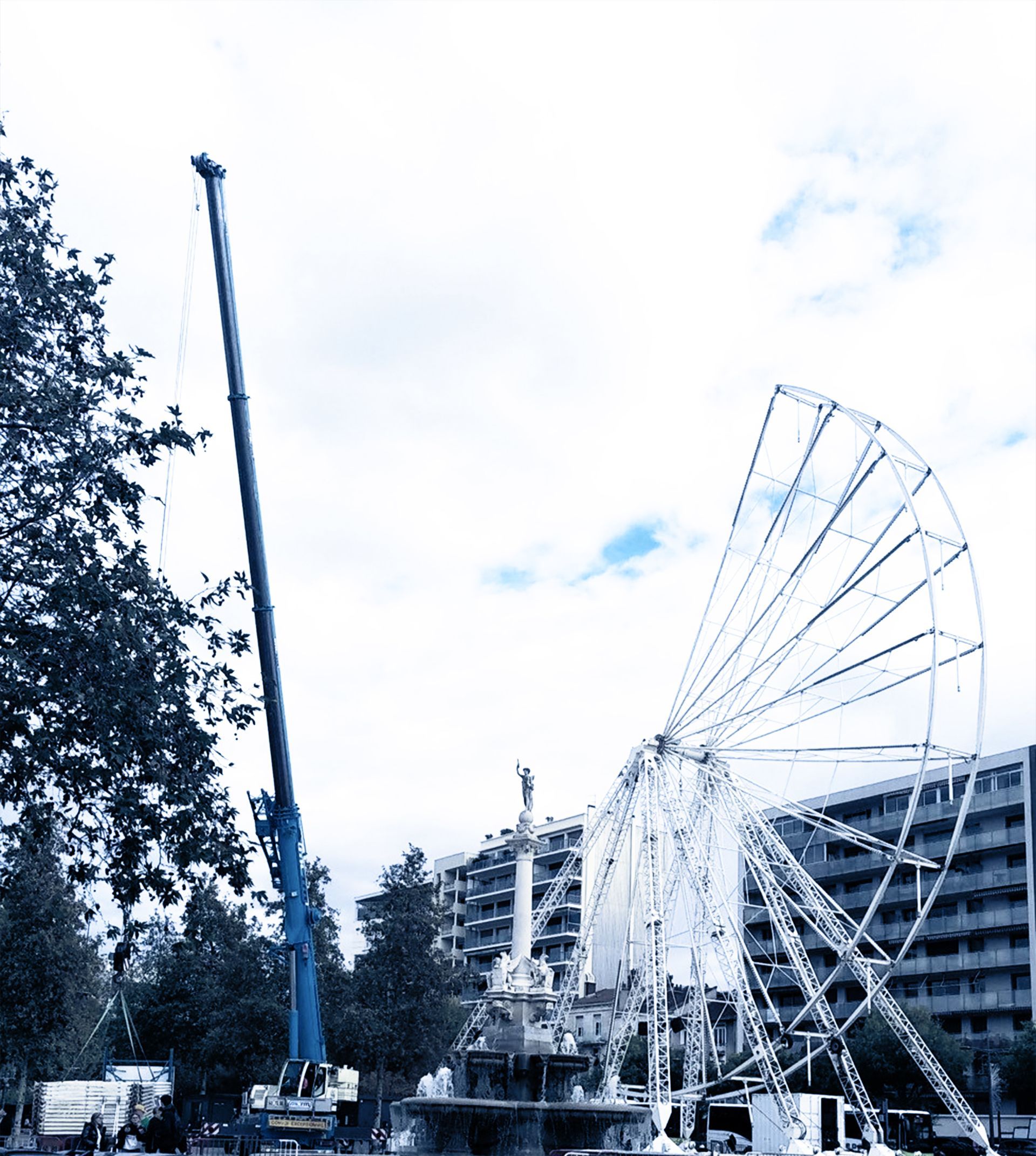 Un bras de grue déployé à proximité d'une grande roue en construction