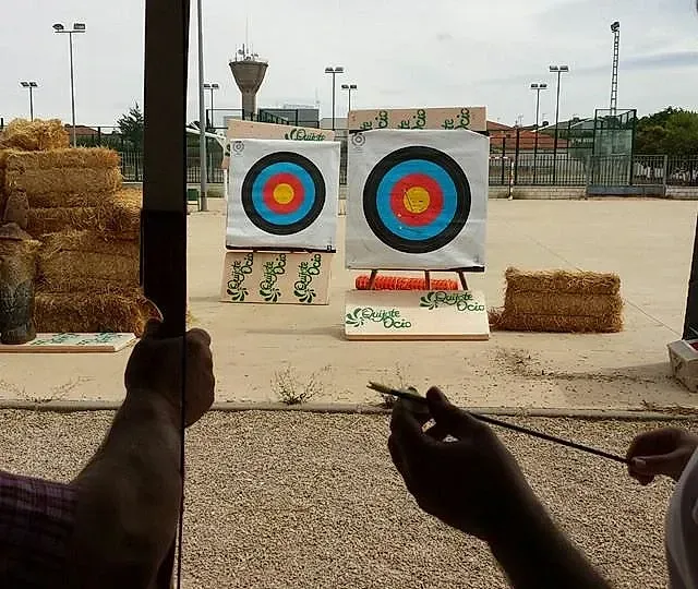 Una persona está apuntando un arco a un objetivo.