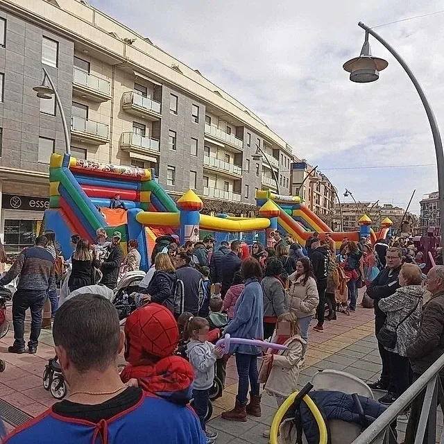 Un grupo de personas se reúne frente a un castillo inflable.