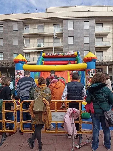 Un grupo de personas están de pie alrededor de una casa inflable.
