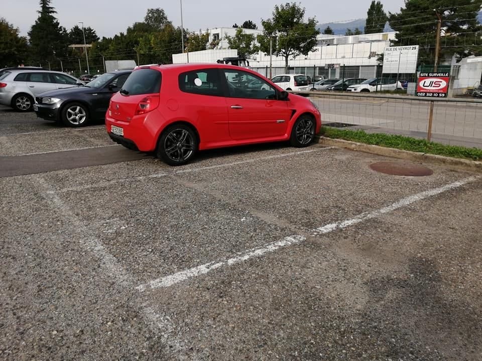 Une voiture rouge est garée sur un parking | UIS Sécurité