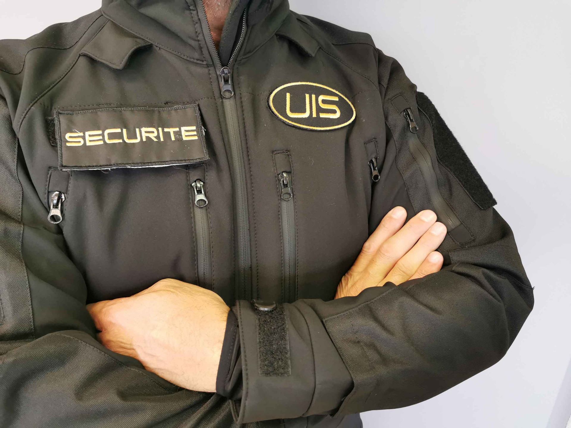 Un homme portant une veste noire avec le mot sécurité dessus | UIS Sécurité