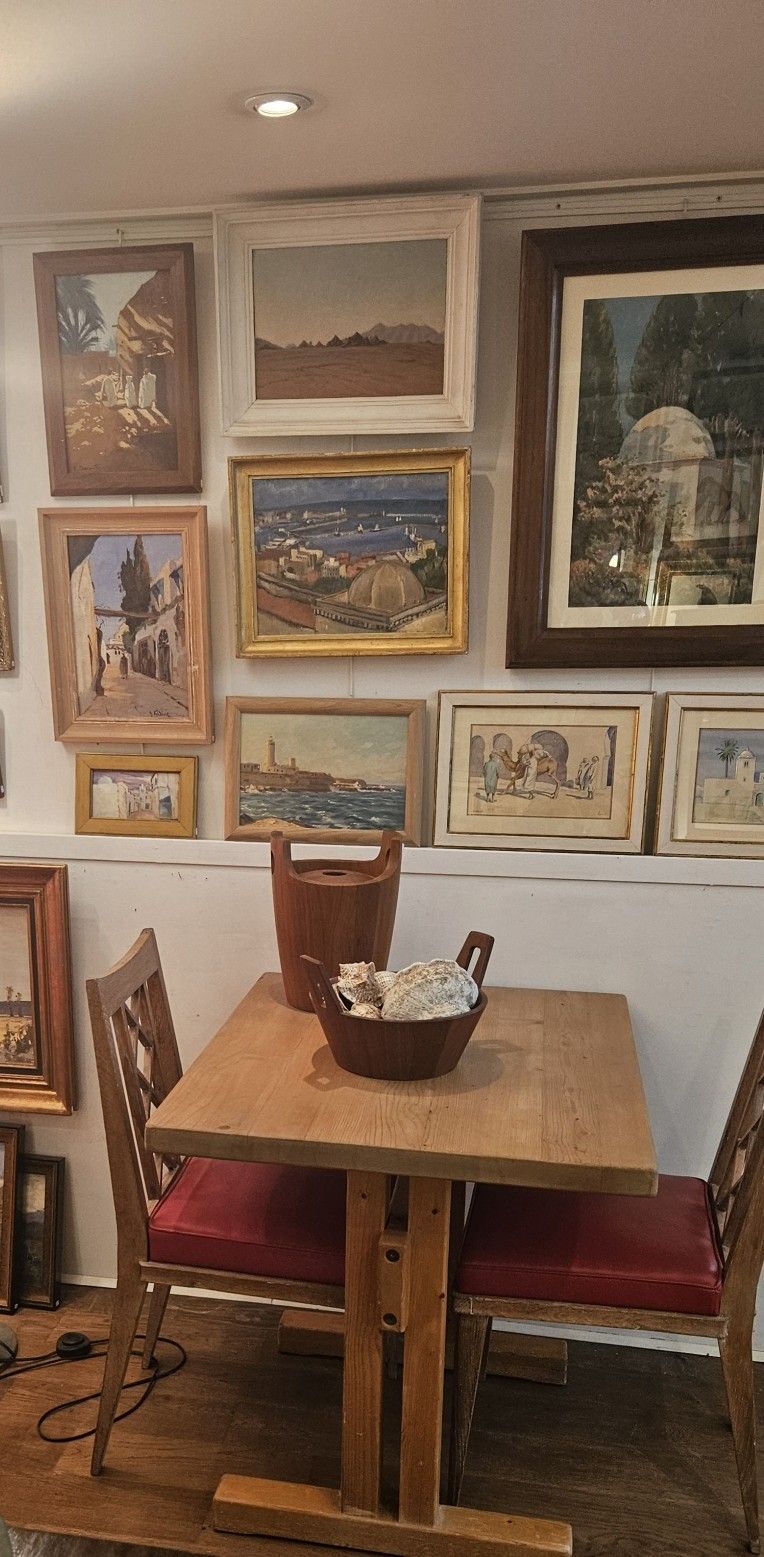 Des tableaux alignés sur un mur blanc