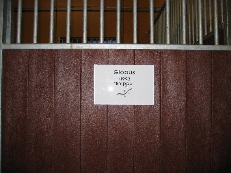 Valkoinen kyltti pienellä tekstillä teipattu ruskeaan puuoveen tai kojuun.