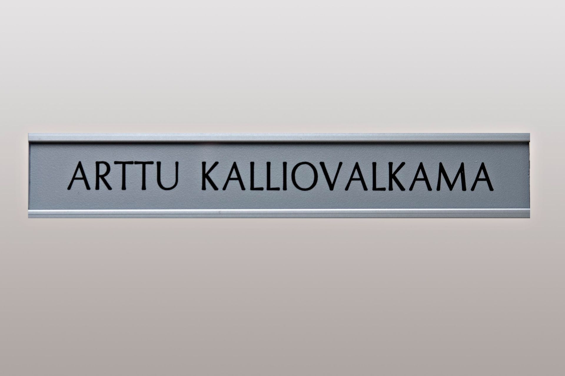 Gray nameplate with black text reading “ARTTU KALLIOVALKAMA”
