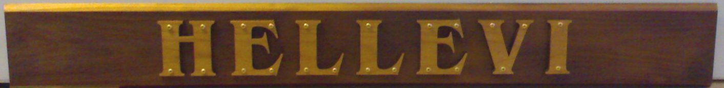 Kultaiset kirjaimet, joissa lukee ”HELLEVI” tummassa puisessa kyltissä.
