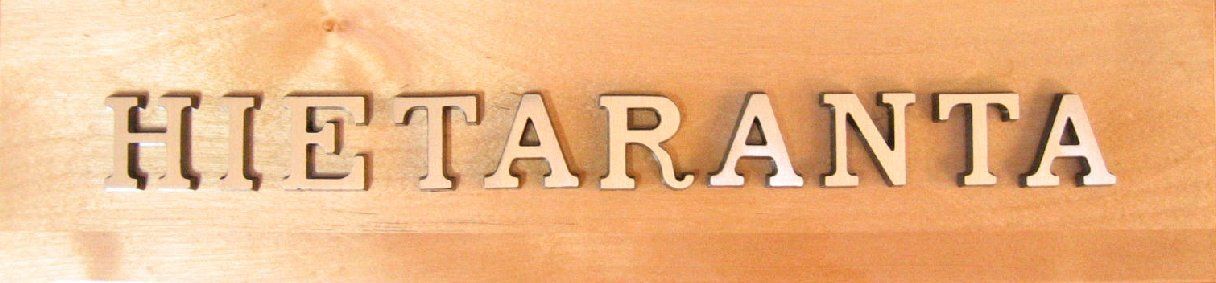 Kohokuvioitu ruskea teksti ”HIETARANTA” vaalealla taustalla