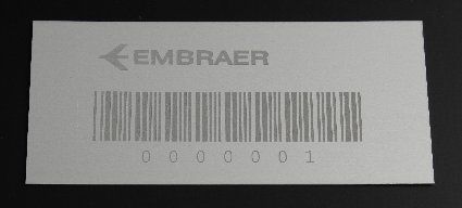 Harmaa EMBRAER-tarra, jossa on viivakoodi ja sen alla numero 0000001.
