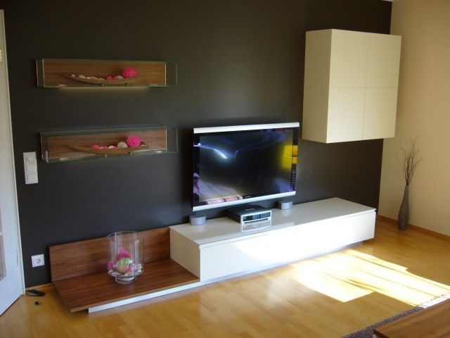 Ein Wohnzimmer mit einem Flachbildfernseher auf einem weißen Ständer