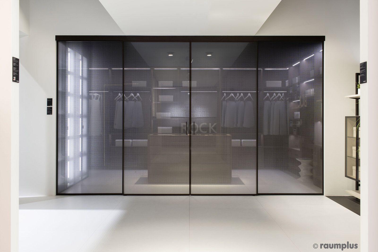 Ein begehbarer Kleiderschrank mit Glasschiebetüren