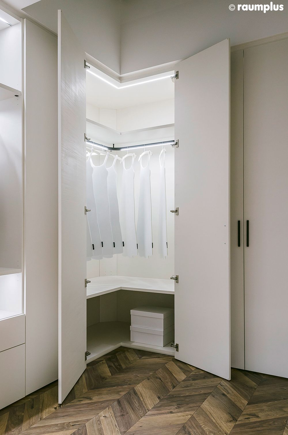 Ein Eckschrank mit Holzboden und weißen Türen.